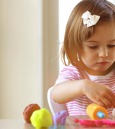 young girl plays with playdough