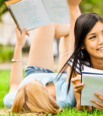 teen girls read on grass